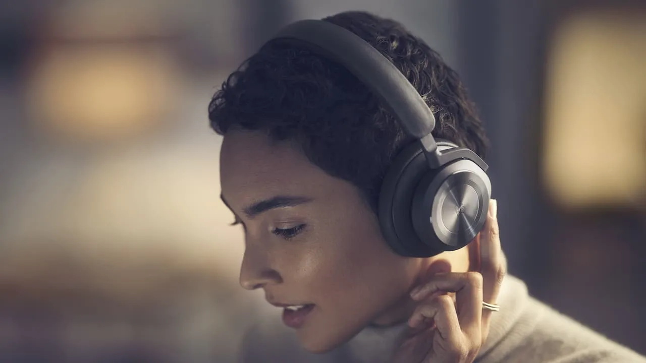Woman adjusting beoplay hx black headphones lifestyle